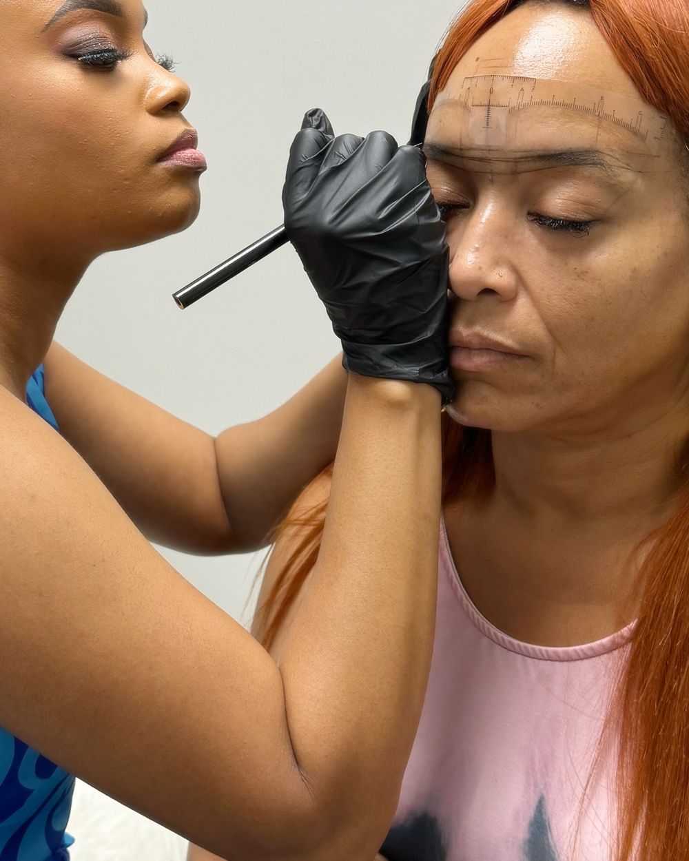 Sky measuring and mapping a client's brows with a brow ruler before the procedure